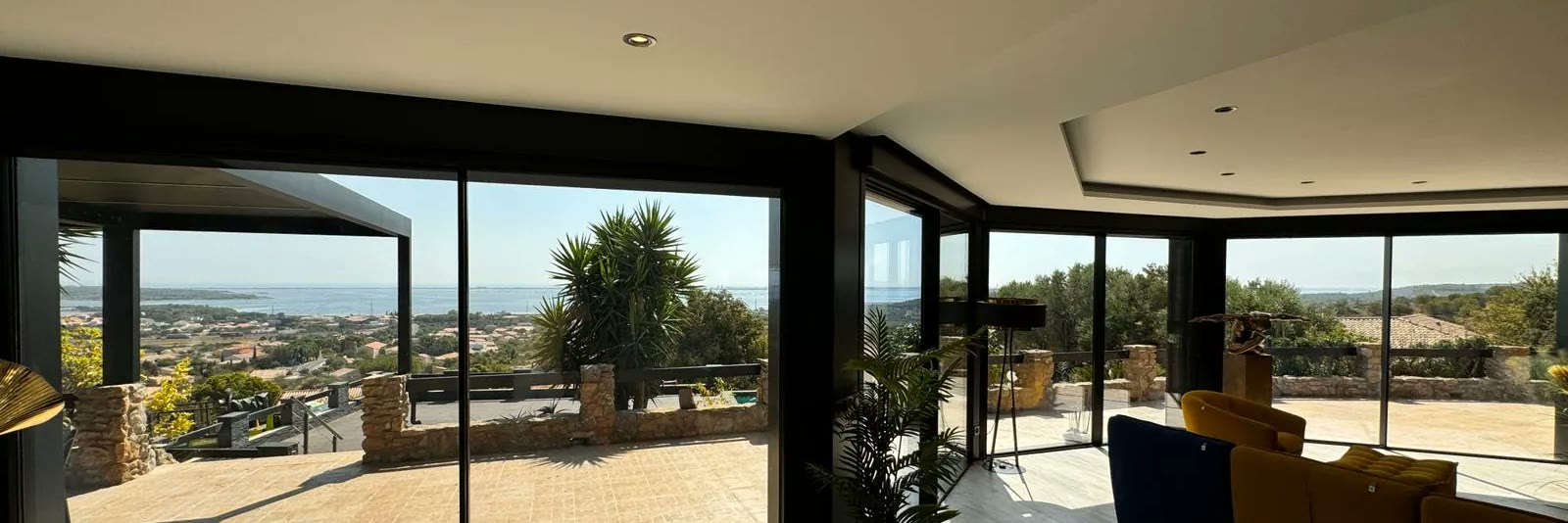 Aluminium sliding system with a large glazed area, opening onto a terrace and the view